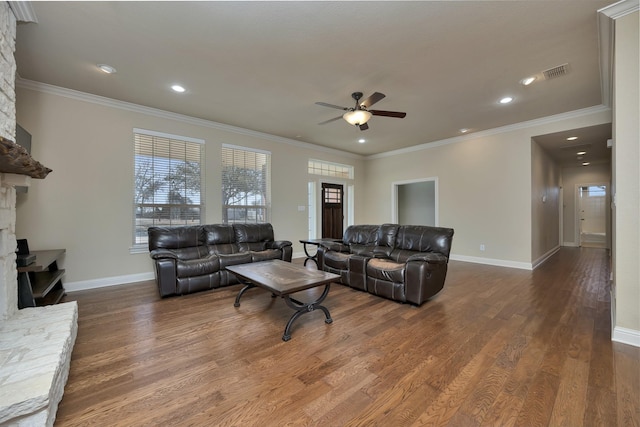 living area with a fireplace, crown molding, and wood finished floors