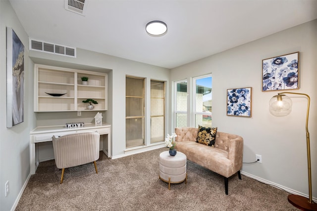 living area with carpet floors, visible vents, and baseboards