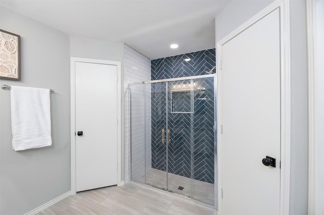 bathroom featuring a stall shower and baseboards