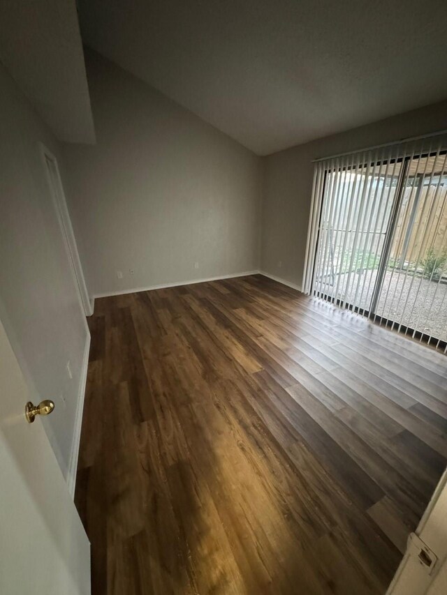 spare room with dark wood finished floors and baseboards