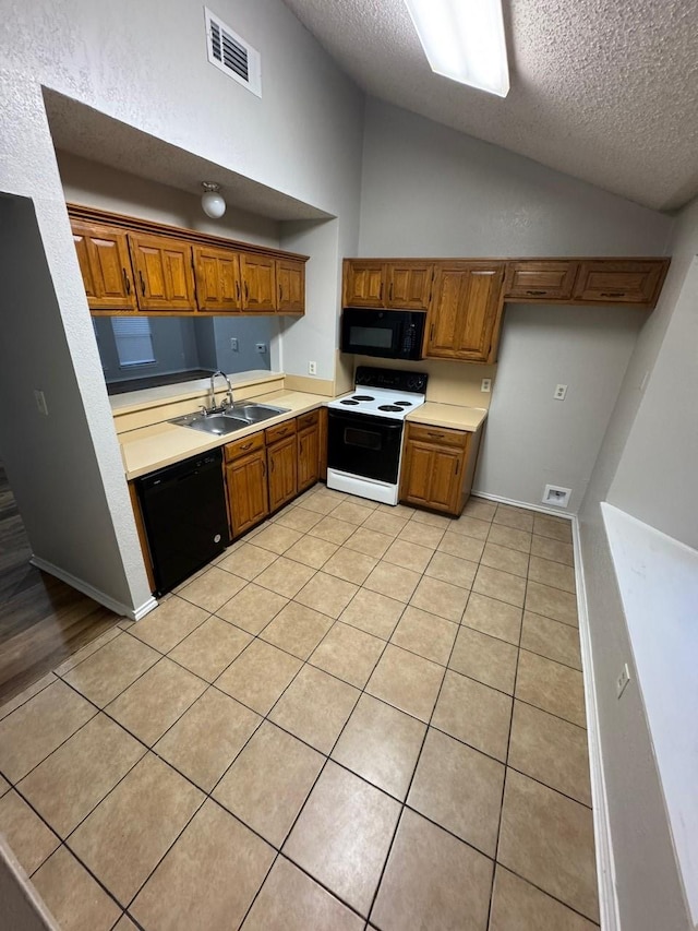 kitchen featuring visible vents, brown cabinets, black appliances, a sink, and light tile patterned flooring