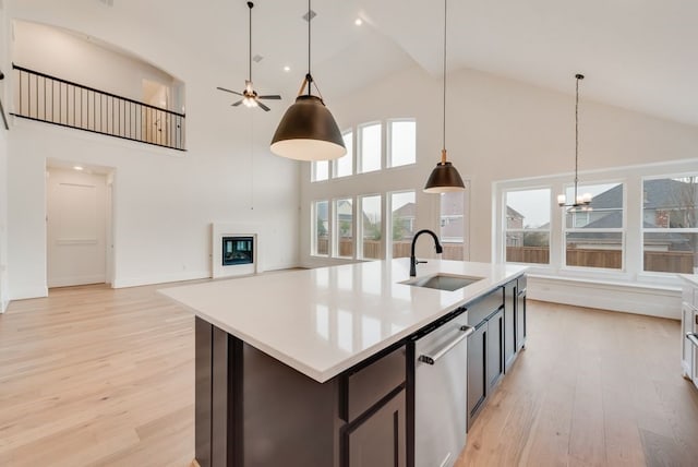 kitchen featuring dishwasher, light countertops, a sink, and light wood-style flooring