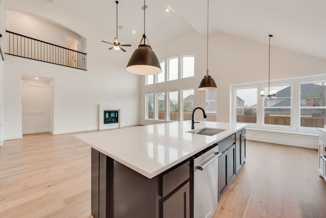 1813 Cousins Trl, Frisco, TX 75034 - kitchen with a sink, stainless steel dishwasher, high vaulted ceiling, light wood-type flooring, and a chandelier