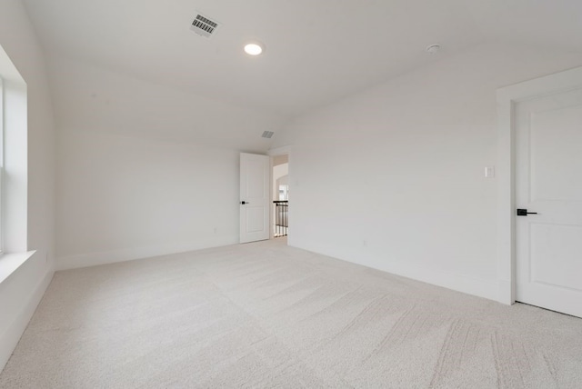 spare room featuring baseboards, visible vents, lofted ceiling, carpet flooring, and recessed lighting