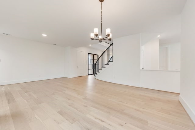 spare room featuring recessed lighting, light wood-style flooring, stairway, an inviting chandelier, and baseboards