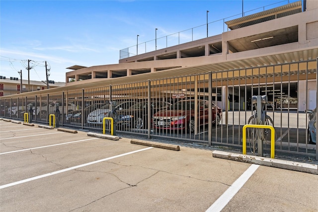 partially covered parking lot featuring fence