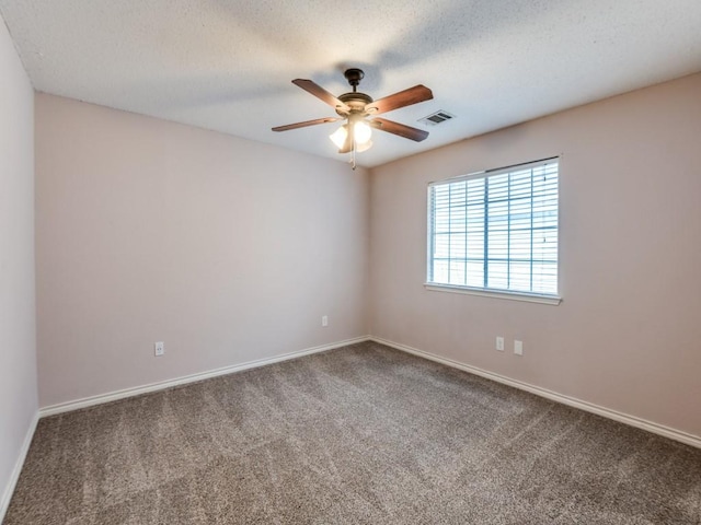 carpeted spare room featuring baseboards, ceiling fan, visible vents, and a textured ceiling