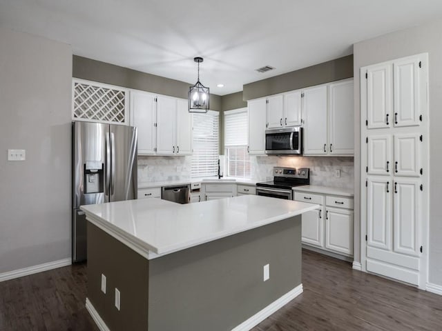 kitchen with stainless steel appliances, white cabinetry, a sink, and visible vents