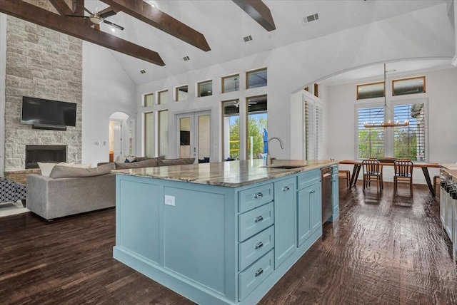 kitchen featuring white cabinetry, a large island with sink, a breakfast bar area, stainless steel appliances, and a sink