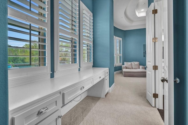 hallway featuring light carpet and baseboards