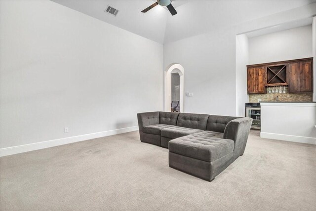 living room featuring a bar, high vaulted ceiling, visible vents, and a ceiling fan