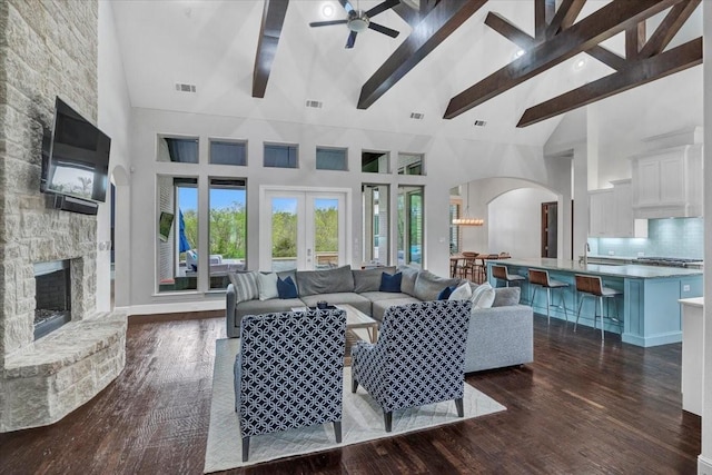 entrance foyer with arched walkways, wood finished floors, french doors, and an inviting chandelier