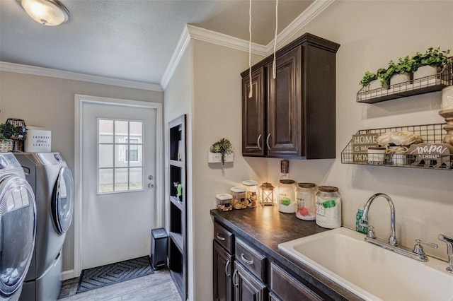 laundry area with washer and clothes dryer, cabinet space, crown molding, and a sink