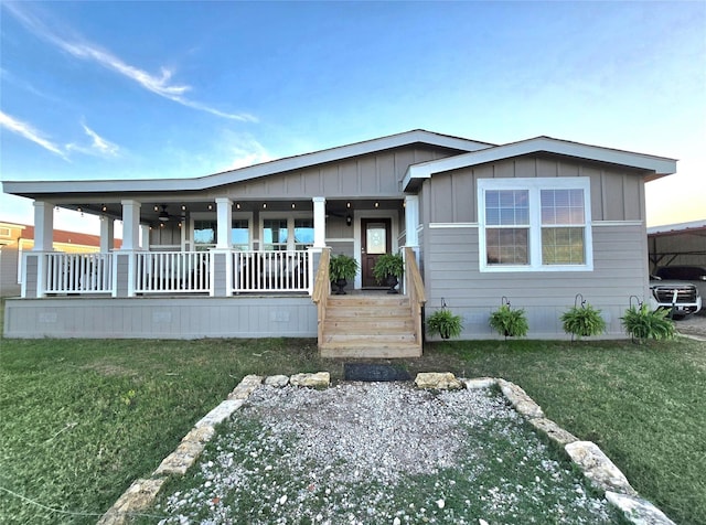 view of front of house with a porch, a front lawn, and board and batten siding