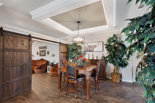 dining space featuring dark wood-style floors, a chandelier, a barn door, a tray ceiling, and visible vents
