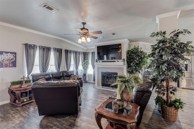 living area featuring ornamental molding, ceiling fan, a fireplace with raised hearth, baseboards, and visible vents