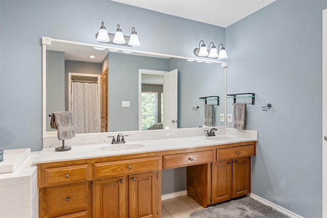 bathroom with double vanity, baseboards, and a sink