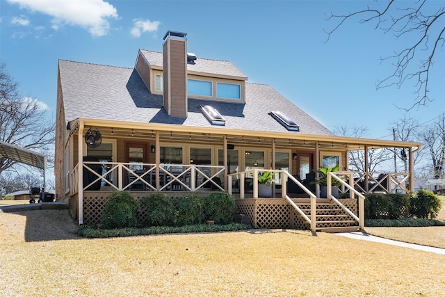 view of front of home featuring a shingled roof, a front yard, covered porch, and a chimney