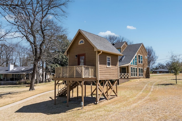 rear view of property with a wooden deck and roof with shingles