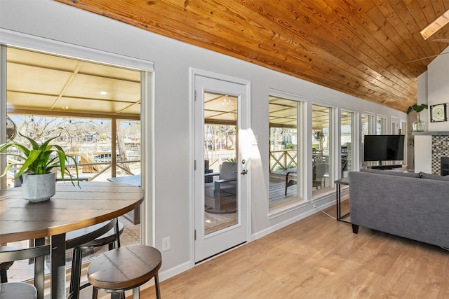 interior space featuring vaulted ceiling, wood ceiling, baseboards, and light wood finished floors