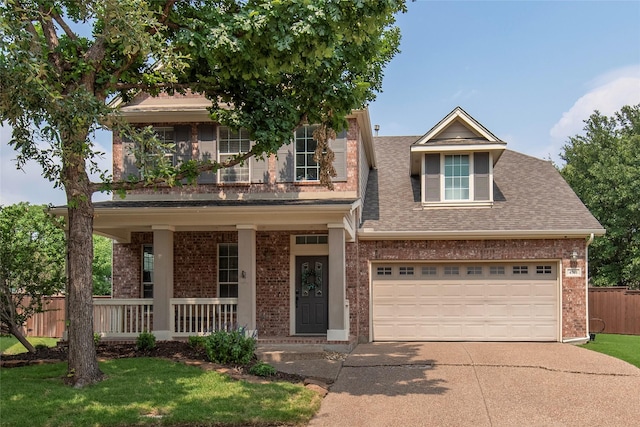 view of front of house featuring driveway, roof with shingles, a porch, and brick siding