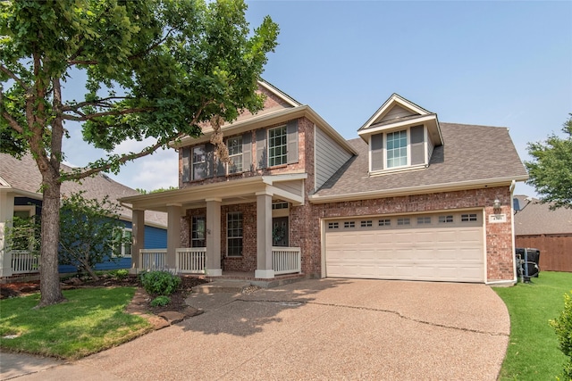 view of front of house with driveway, covered porch, roof with shingles, and brick siding