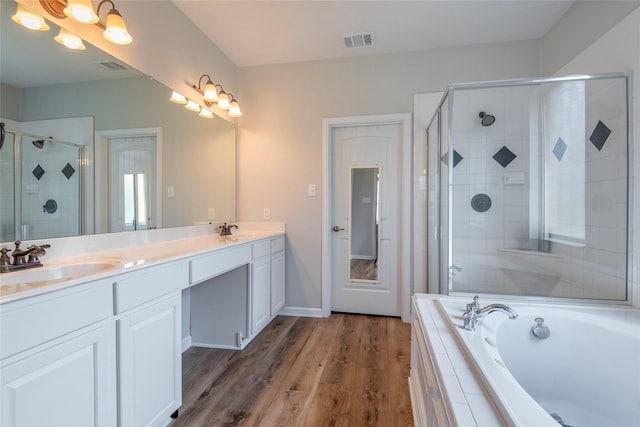 full bathroom with double vanity, a shower stall, visible vents, and a sink