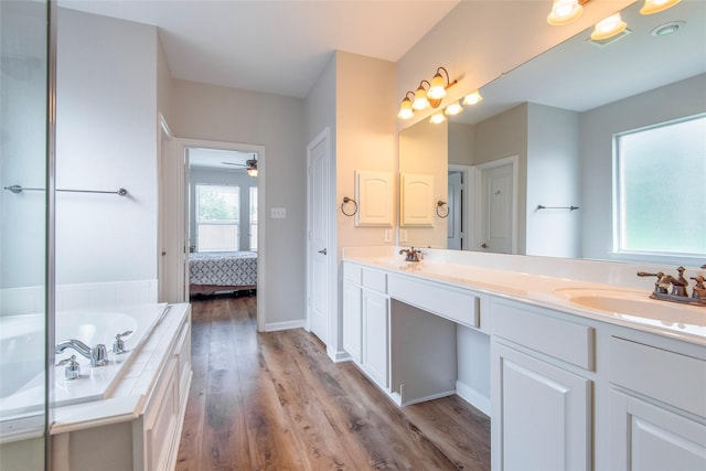 full bath featuring double vanity, wood finished floors, and a sink