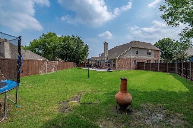 view of yard featuring a trampoline and a fenced backyard