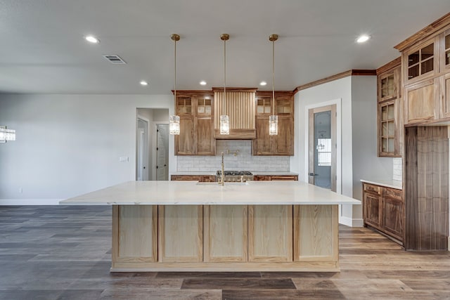 kitchen featuring visible vents, decorative backsplash, a spacious island, dark wood-style floors, and light countertops