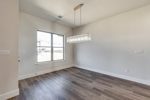 unfurnished room featuring dark wood-style floors, visible vents, and baseboards