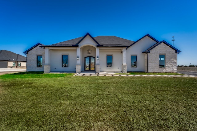 modern farmhouse featuring stone siding, french doors, roof with shingles, stucco siding, and a front yard