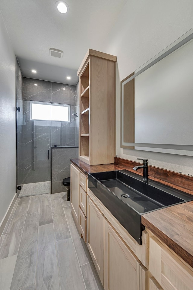 bathroom featuring toilet, a shower stall, vanity, and recessed lighting