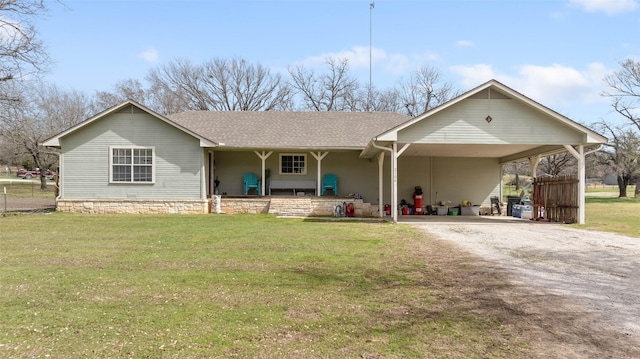 view of front of property with driveway, a shingled roof, a front lawn, and an attached carport