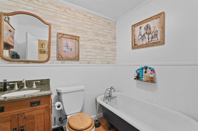 full bath featuring toilet, a soaking tub, ornamental molding, a textured ceiling, and vanity