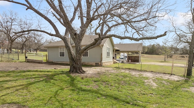 view of home's exterior with roof with shingles, a lawn, fence, and driveway