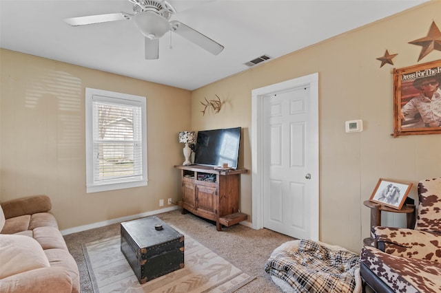 living area with light colored carpet, visible vents, ceiling fan, and baseboards