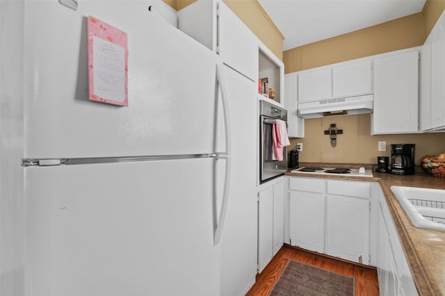 kitchen with white cabinets, under cabinet range hood, white appliances, and dark wood-type flooring