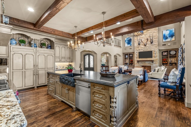 kitchen featuring arched walkways, dark wood-style flooring, a fireplace, and a sink