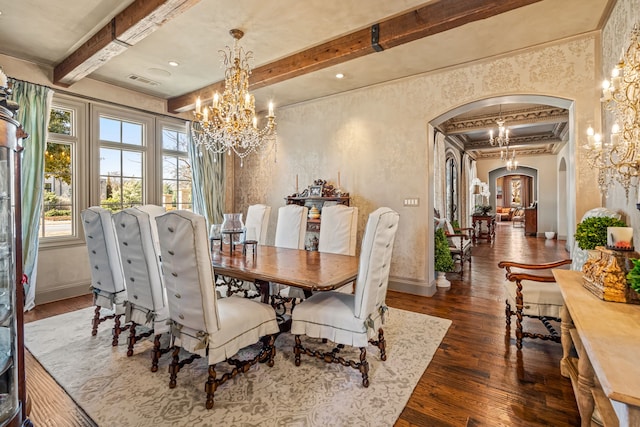 dining space featuring visible vents, arched walkways, baseboards, hardwood / wood-style floors, and an inviting chandelier