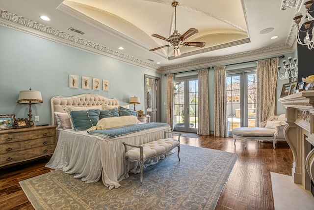 bedroom with visible vents, access to outside, french doors, a tray ceiling, and wood-type flooring