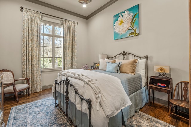 bedroom featuring ornamental molding, wood finished floors, and baseboards