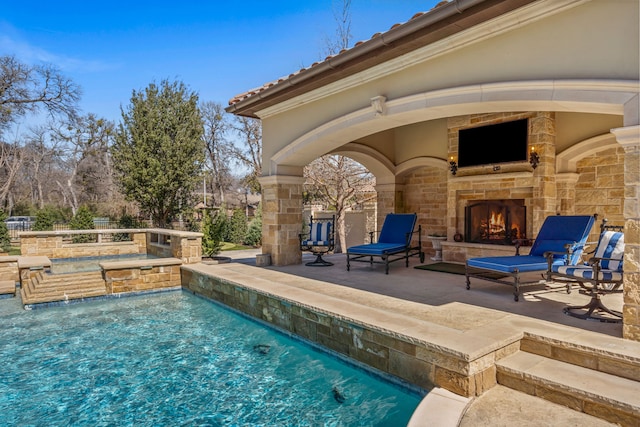 outdoor pool with an outdoor stone fireplace and a patio area