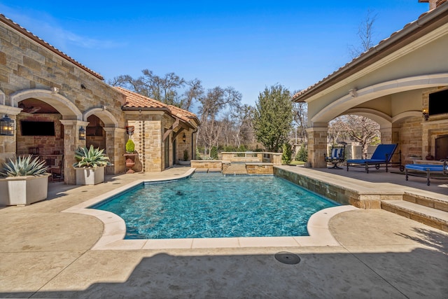 outdoor pool with a patio and an outdoor fireplace