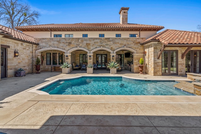 pool with a patio area and french doors