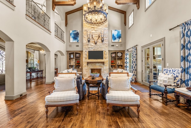 interior space with arched walkways, a fireplace, a chandelier, and hardwood / wood-style flooring