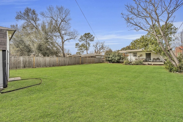 view of yard featuring a fenced backyard and a wooden deck