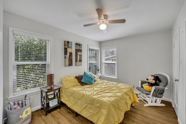 bedroom with a ceiling fan, baseboards, and wood finished floors