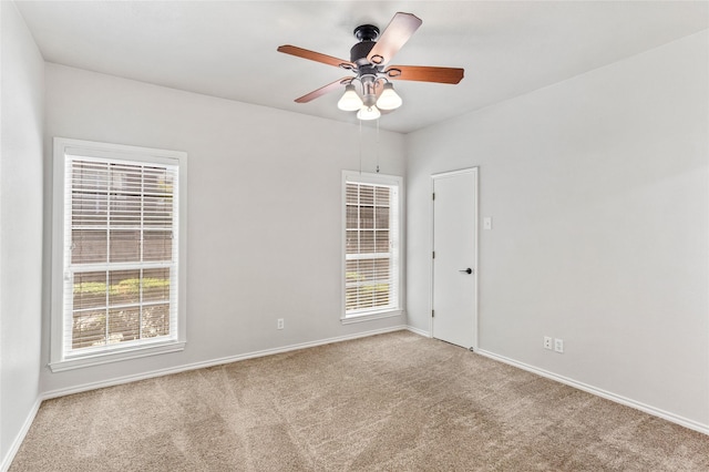 empty room with ceiling fan, carpet floors, and baseboards