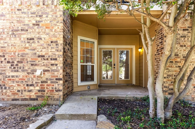 view of exterior entry with french doors and brick siding